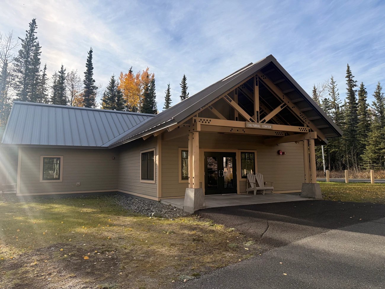 Full frame shows the public cultural-center exterior and entrance with trees and autumn foliage; no visitors or restricted interior material visible.