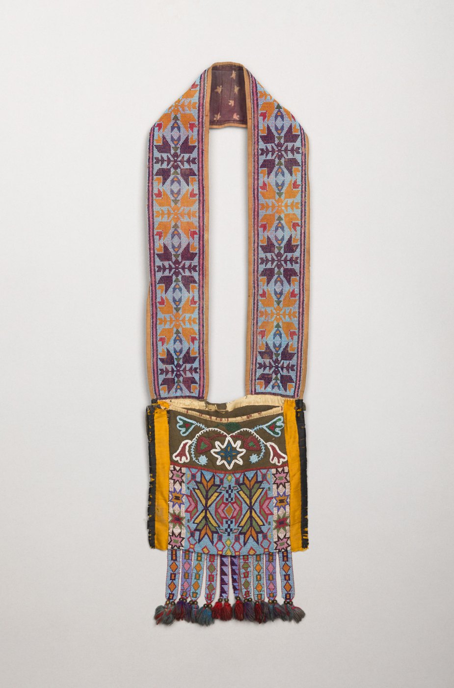 Complete beaded bandolier bag with a long decorated strap, pouch and beaded tabs.