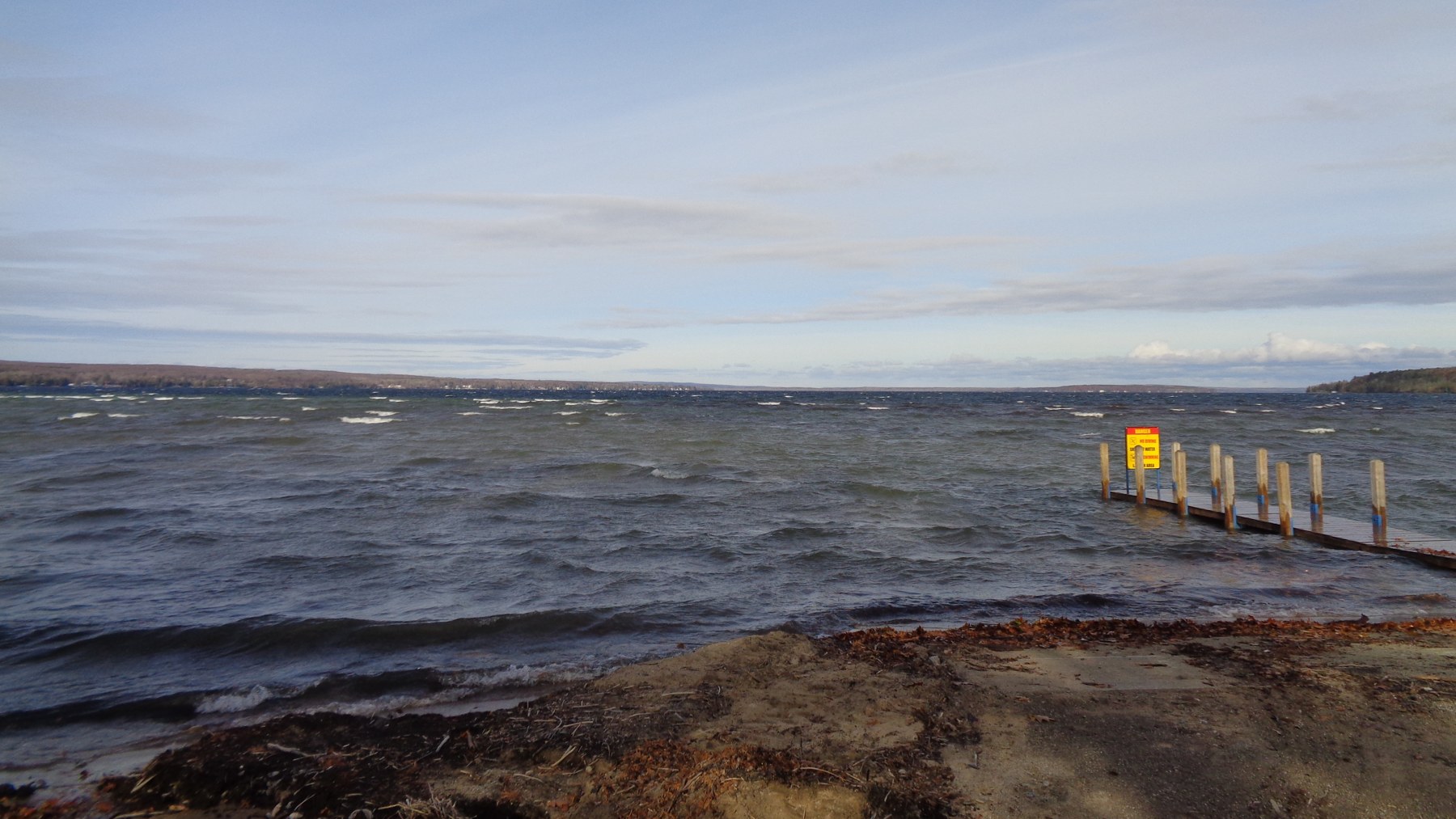 A wind-ruffled Burt Lake shoreline and a small dock in November.