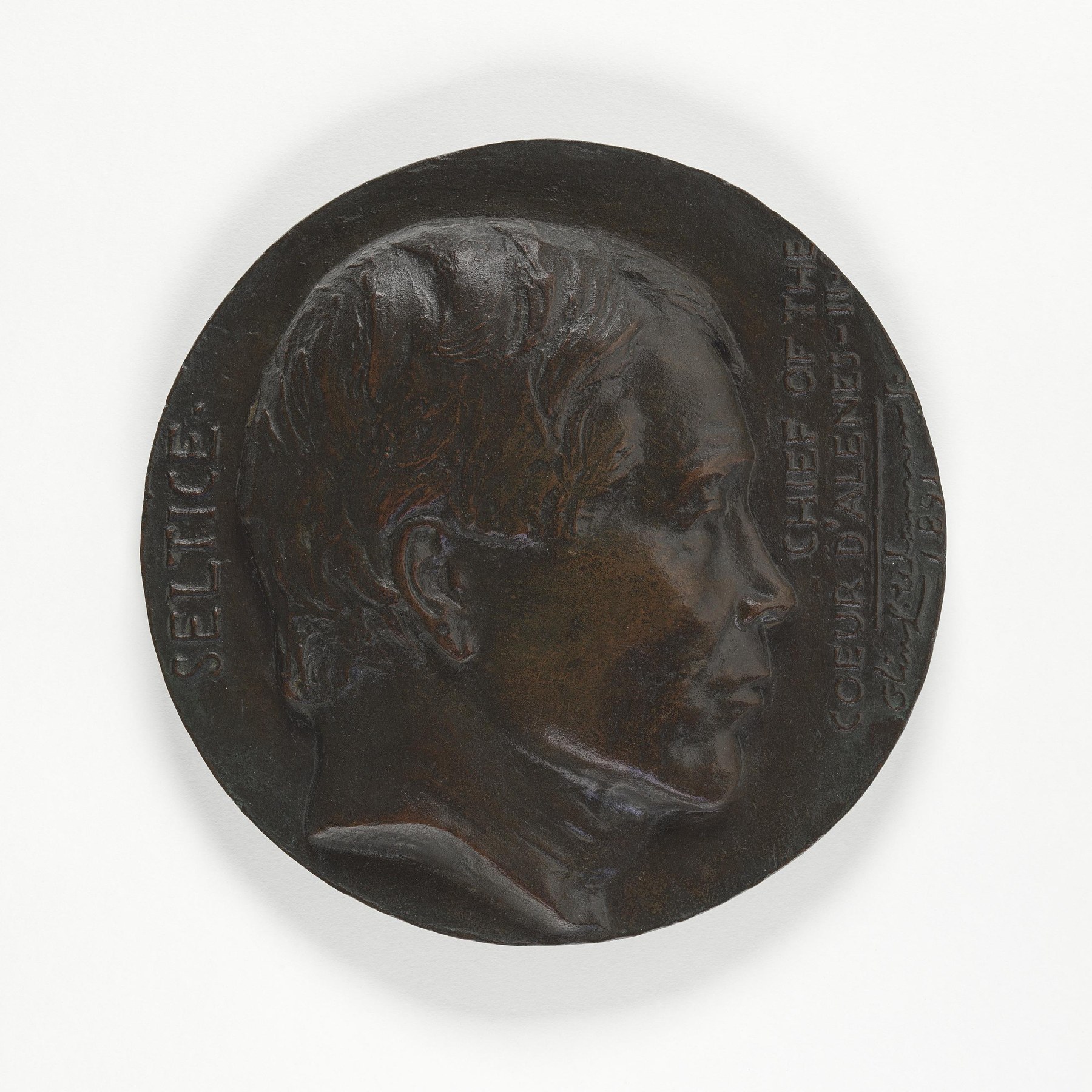 A round bronze relief with a right-facing portrait of Seltice and lettering identifying him as a Coeur d’Alene chief.