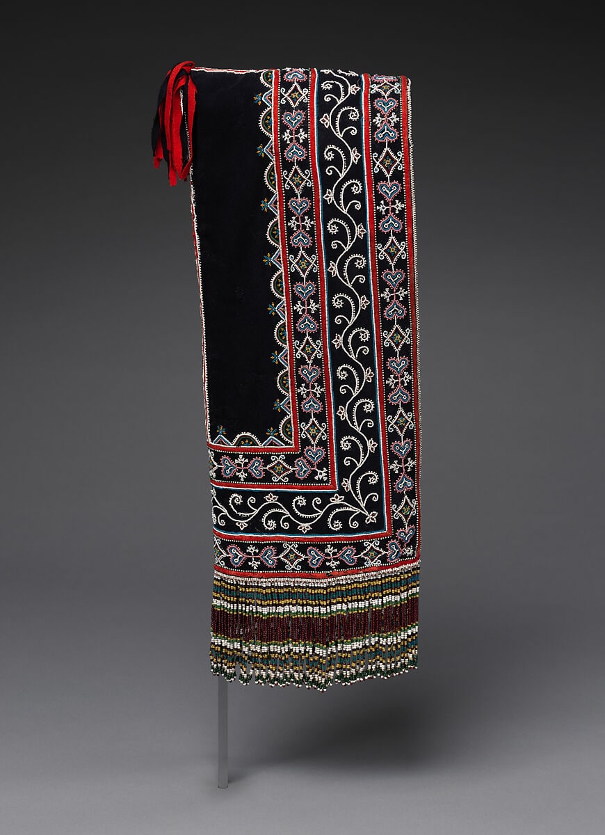 A black James Bay Cree hood with red ties, floral and geometric beadwork and a beaded lower fringe.