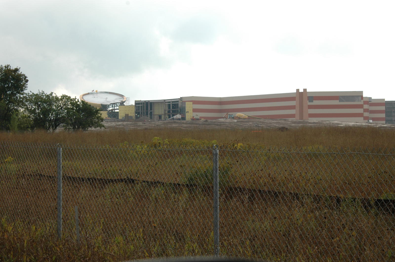 Odawa Casino building under construction behind a chain-link fence and grassy ground,2006.